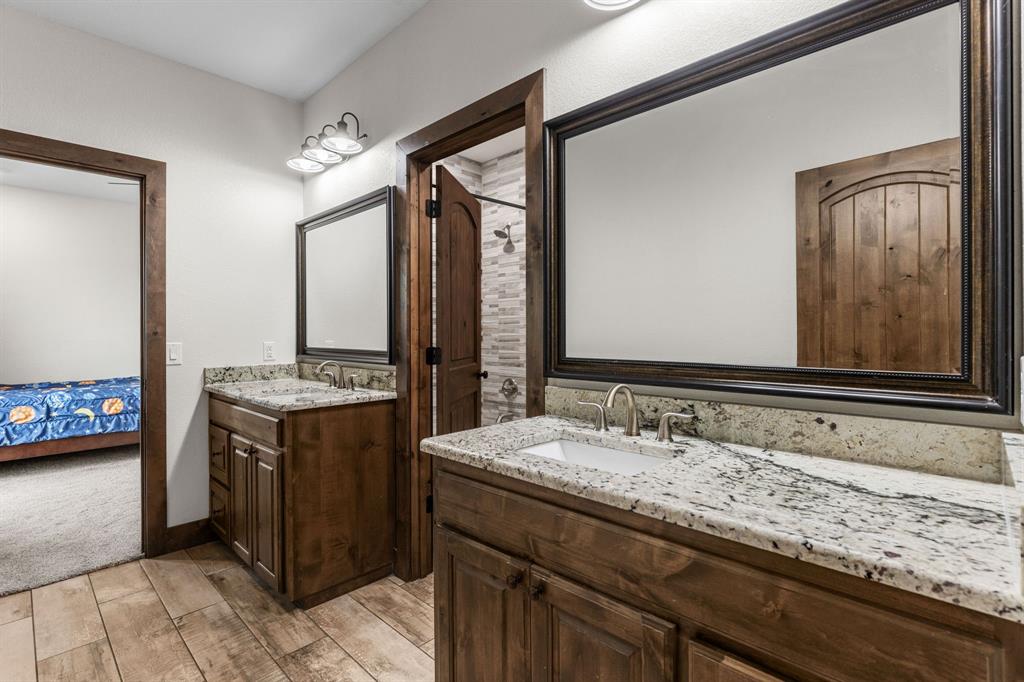 515 Sales Road Windthorst, TX 76389 - Photo 27 of 34 a bathroom with a granite countertop sink and a mirror