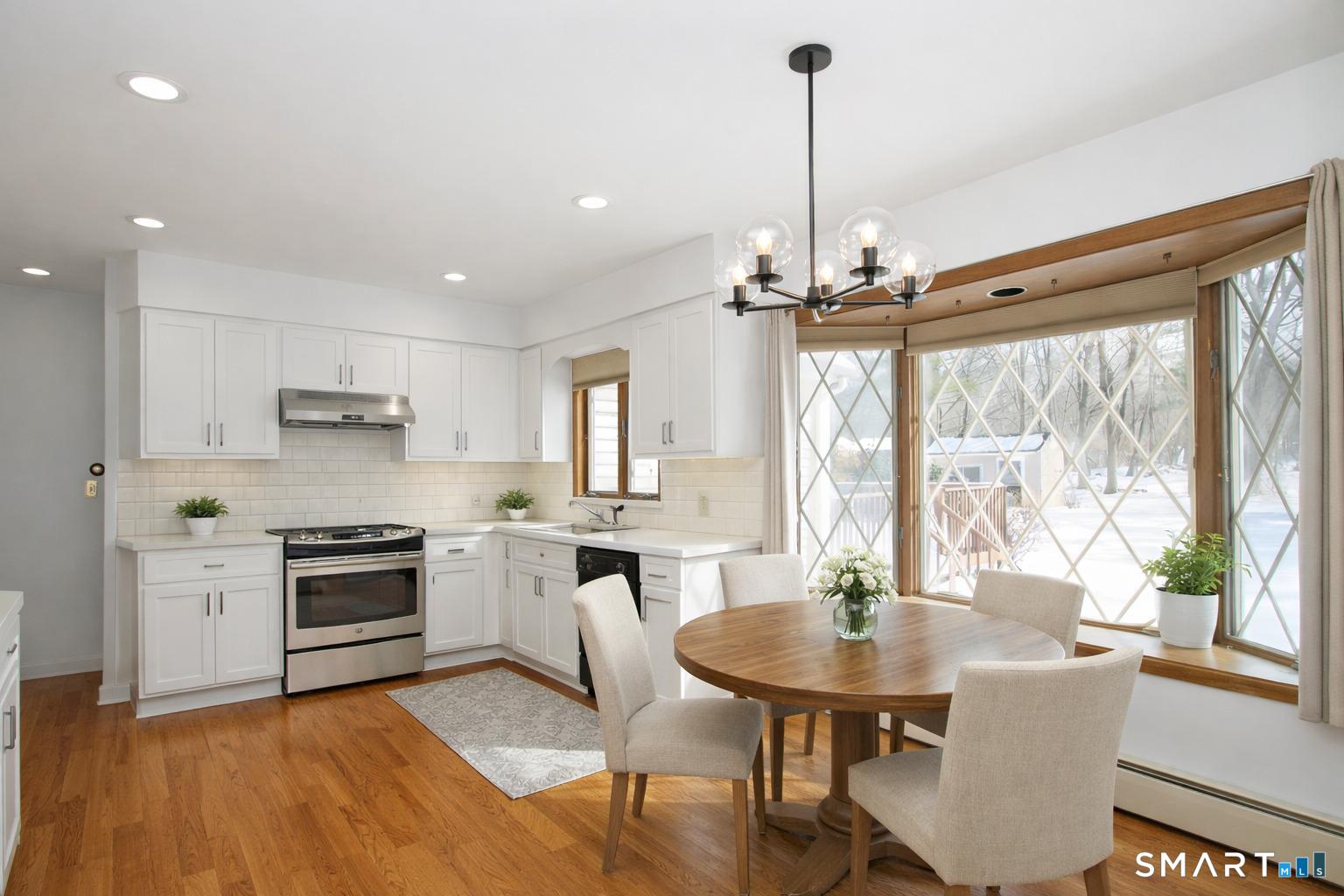 463 Herbert Street Orange, CT 06477 - Photo 17 of 51 a kitchen with a table chairs stove and cabinets