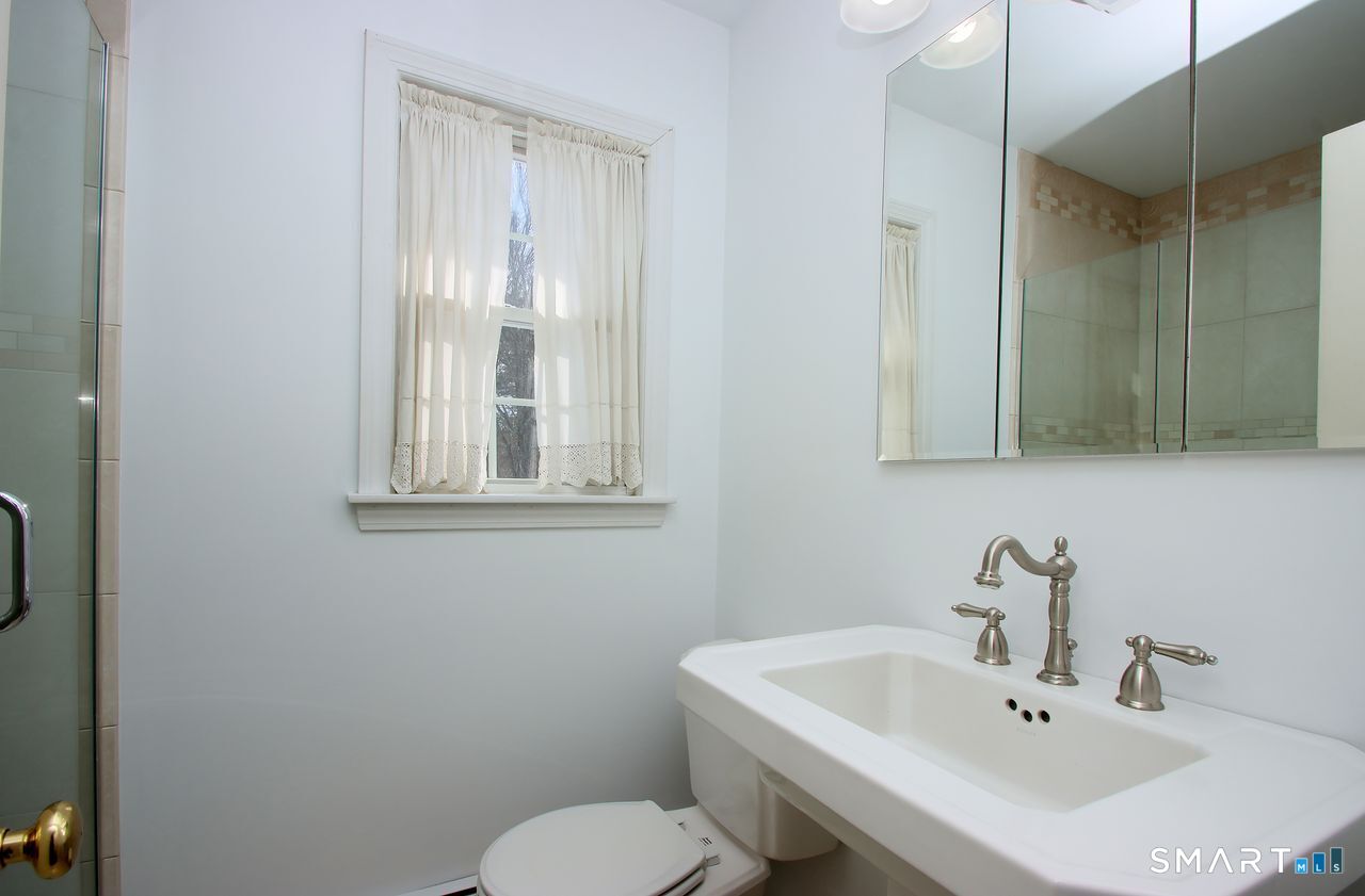 463 Herbert Street Orange, CT 06477 - Photo 20 of 40 a bathroom with a sink a toilet and a mirror