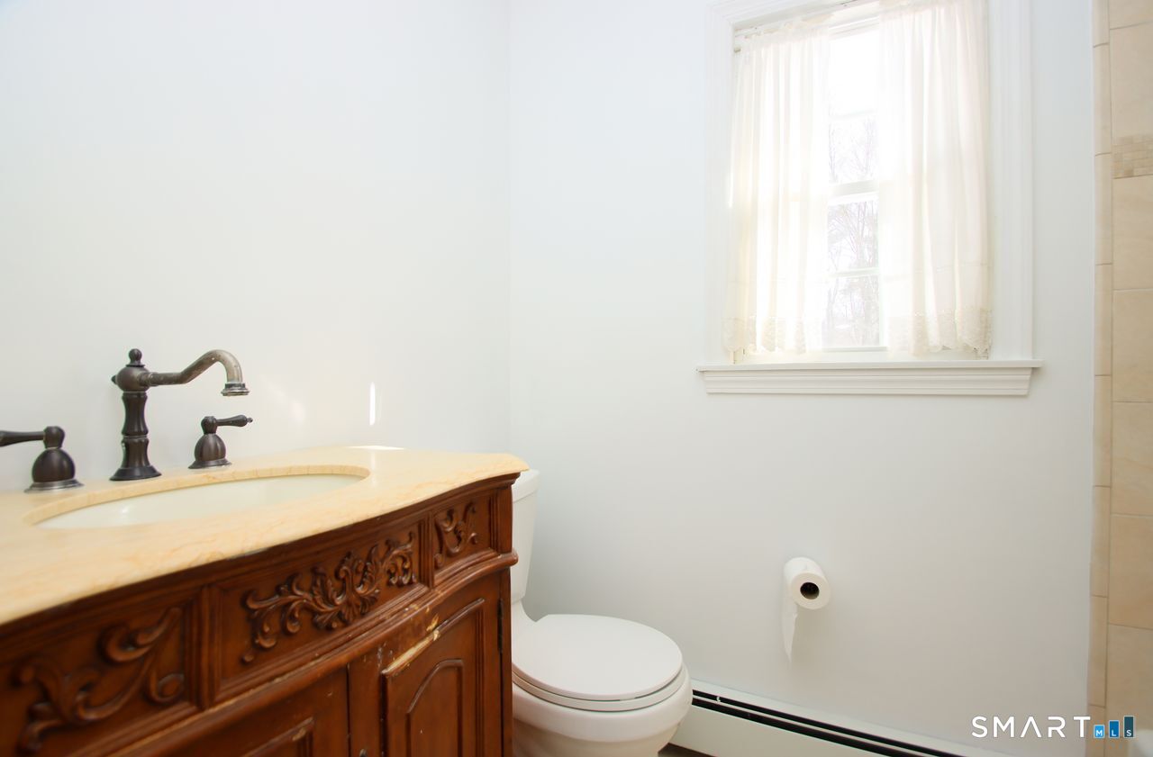 463 Herbert Street Orange, CT 06477 - Photo 28 of 40 a bathroom with a sink a toilet and vanity