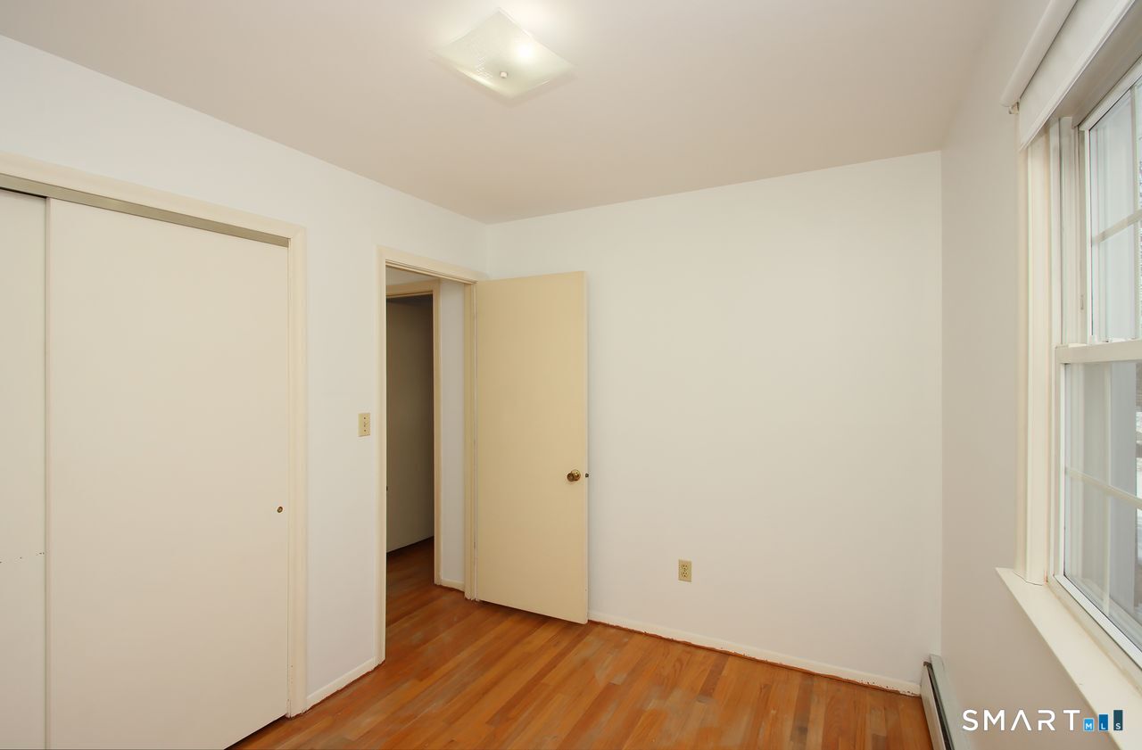 463 Herbert Street Orange, CT 06477 - Photo 31 of 40 a view of an empty room with wooden floor and a window
