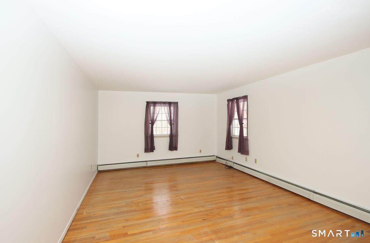 463 Herbert Street Orange, CT 06477 - Photo 33 of 51 a view of an empty room with wooden floor and a window
