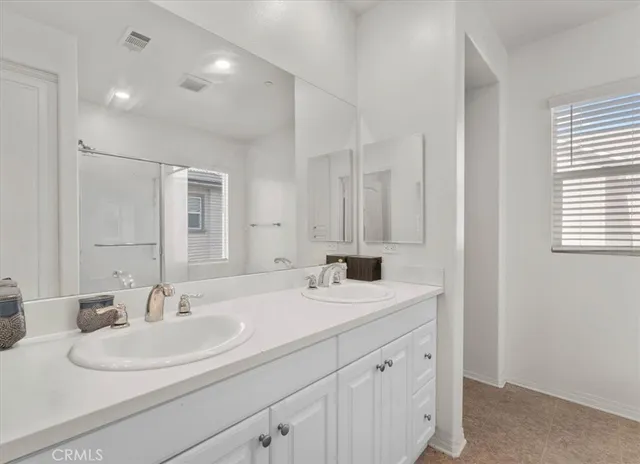 a bathroom with double sink and a mirror