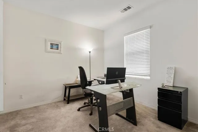 a view of a workspace with furniture and a window