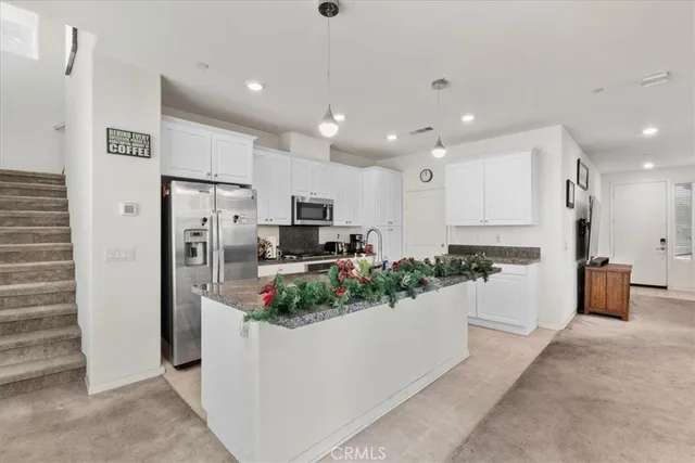 a kitchen with stainless steel appliances kitchen island refrigerator and microwave