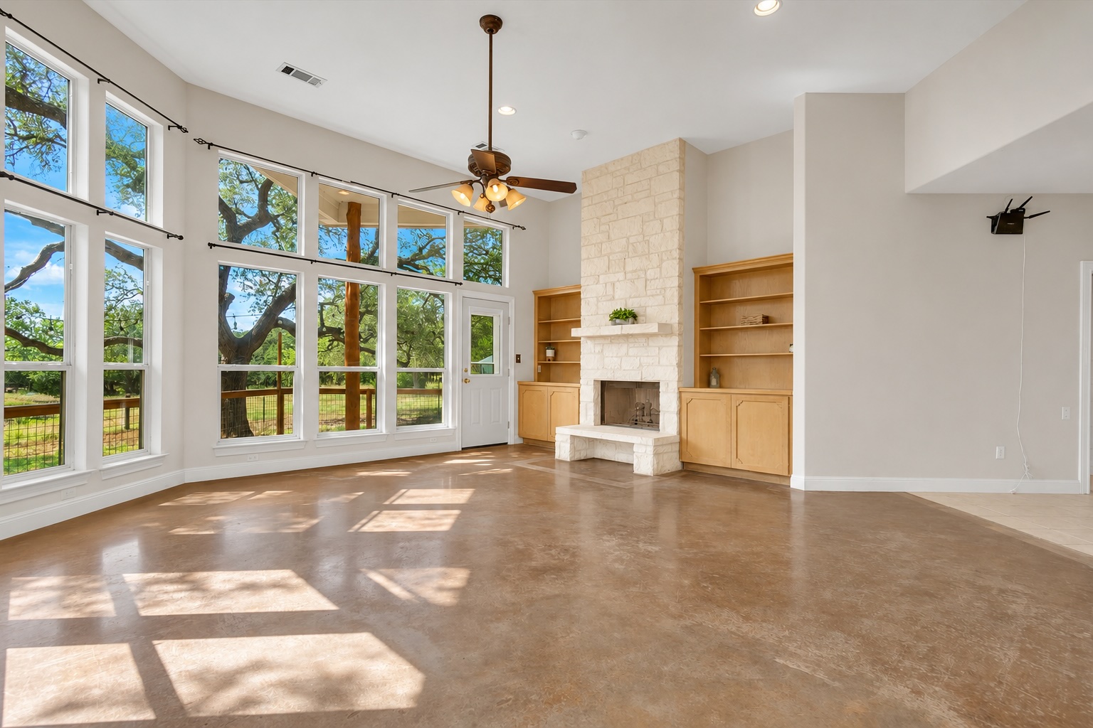 1120 Meadow Ridge Drive Austin, TX 78737 - Photo 11 of 40 A spacious living area with expansive windows provides serene views of mature trees and integrated storage.