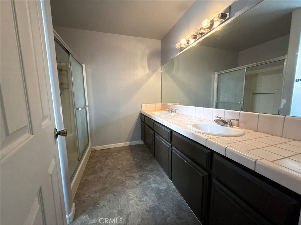 421 Petris Avenue Ridgecrest, CA 93555 - Photo 14 of 18 a bathroom with a double vanity sink and mirror