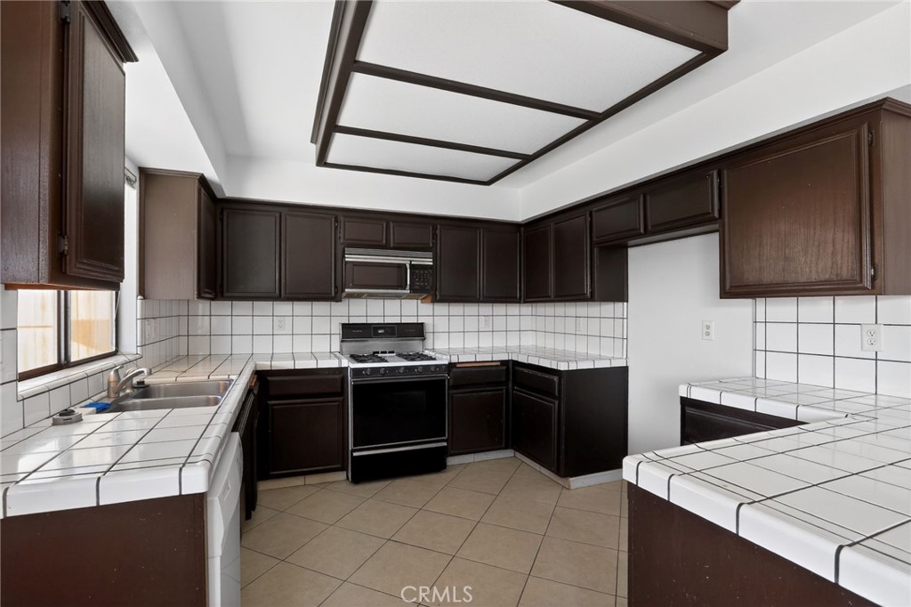 421 Petris Avenue Ridgecrest, CA 93555 - Photo 7 of 18 a kitchen with stainless steel appliances a stove sink microwave and cabinets