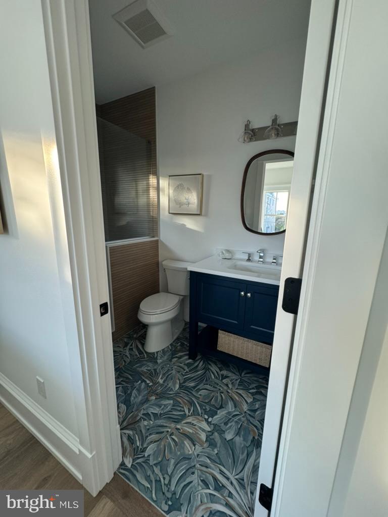 281 7th Street Avalon, NJ 08202 - Photo 38 of 62 a bathroom with a granite countertop toilet sink and a mirror