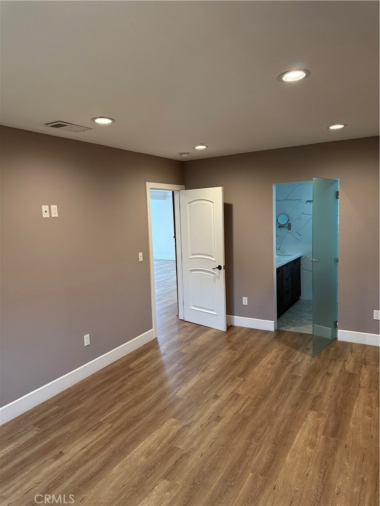 7459 Ruffner Avenue Van Nuys, CA 91406 - Photo 6 of 20 an empty room with wooden floor and windows