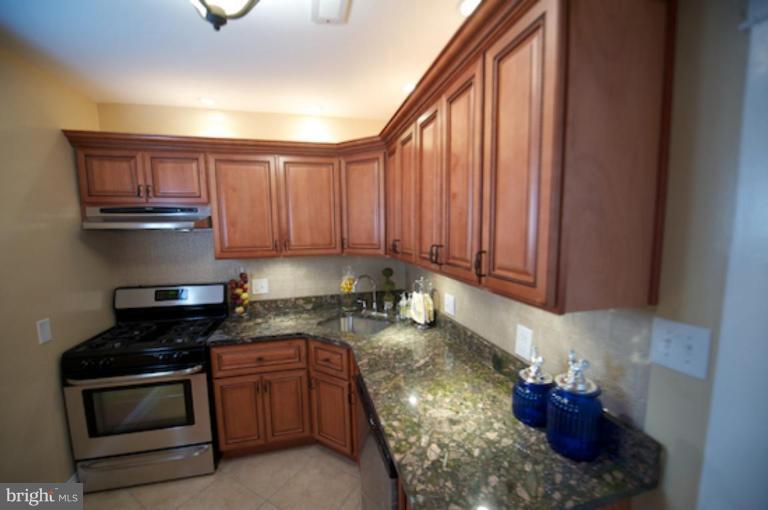 1808 Kinship Road Dundalk, MD 21222 - Photo 2 of 19 a kitchen with granite countertop wooden cabinets and stainless steel appliances