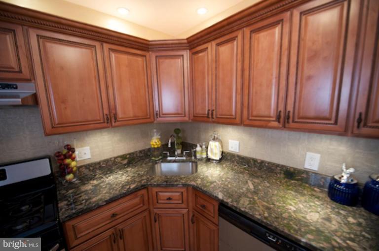 1808 Kinship Road Dundalk, MD 21222 - Photo 3 of 19 a kitchen with granite countertop cabinets and black stainless steel appliances