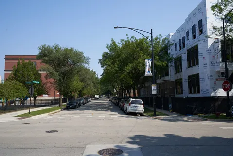 a city street with tall buildings and cars parked on street