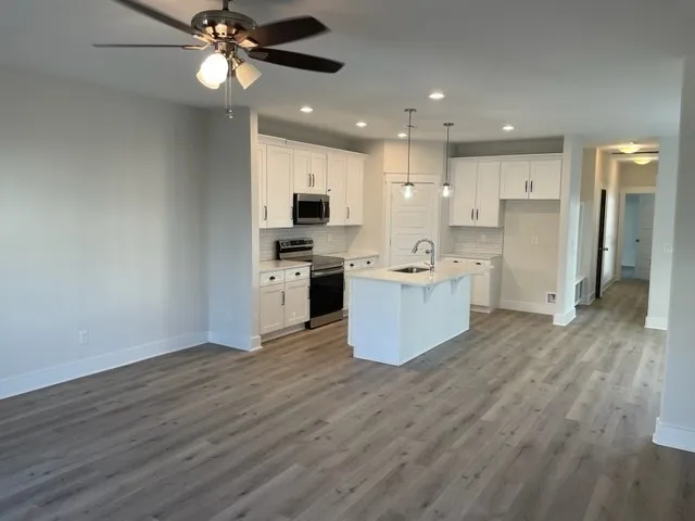 a large kitchen with stainless steel appliances granite countertop a stove oven and a refrigerator