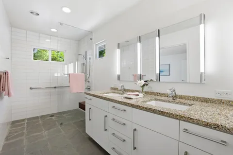 a bathroom with a granite countertop sink mirror and double