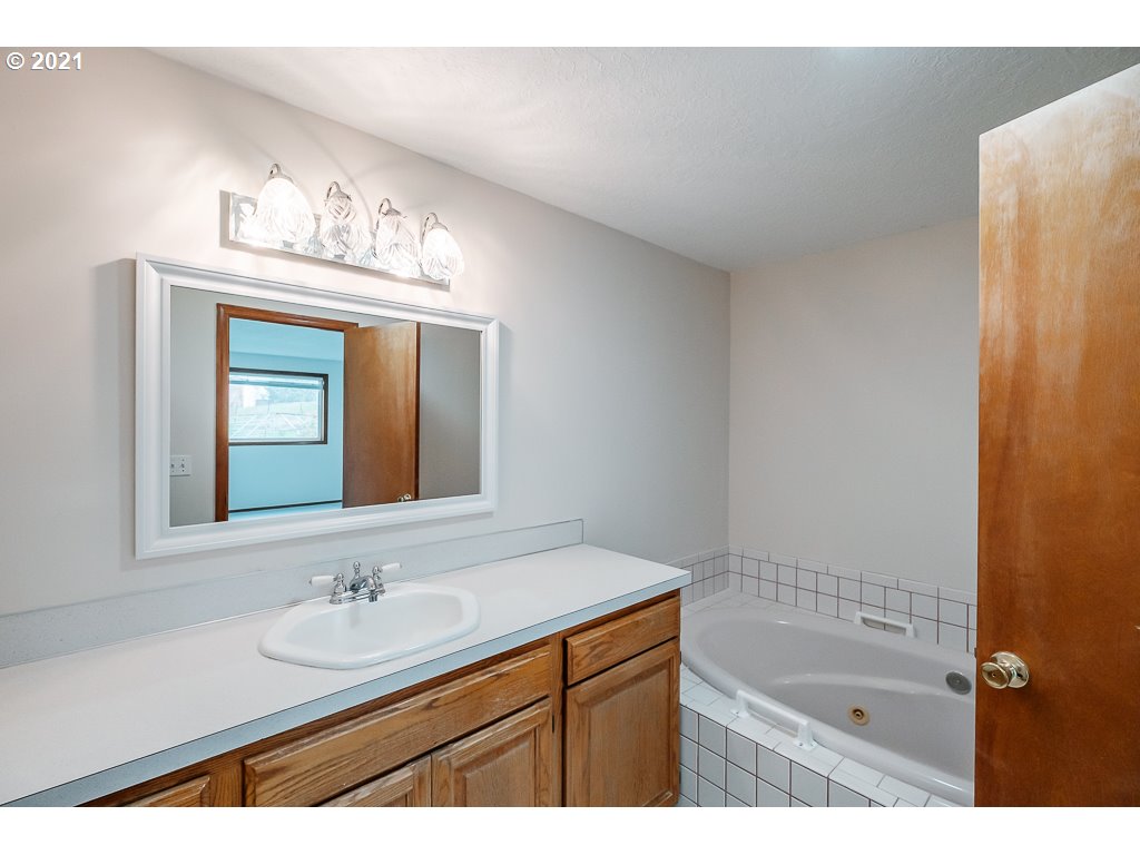 15305 Oakdale Road Dallas, OR 97338 - Photo 15 of 32 a bathroom with a sink a mirror and a bathtub