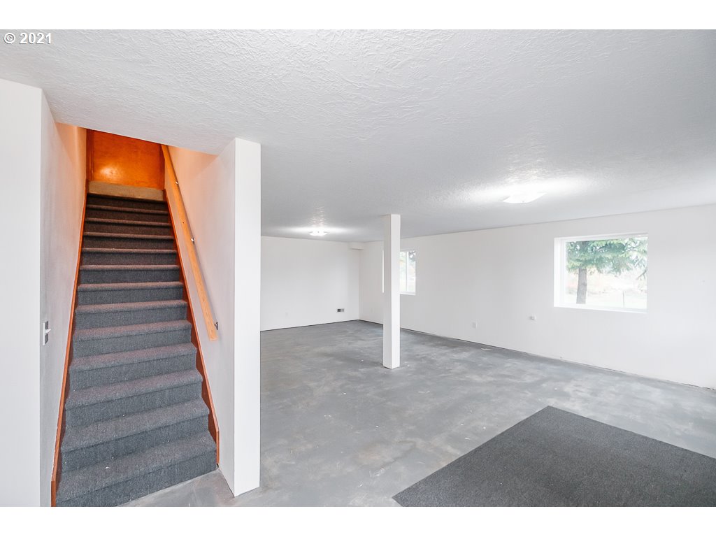 15305 Oakdale Road Dallas, OR 97338 - Photo 22 of 32 a view of an empty room with wooden floor and stairs