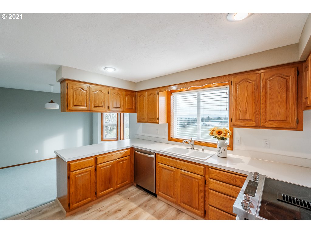 15305 Oakdale Road Dallas, OR 97338 - Photo 8 of 32 a kitchen with stainless steel appliances kitchen island wooden cabinets a window and a sink