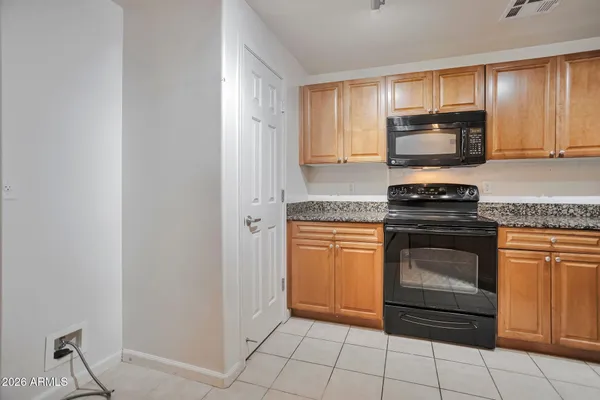 a kitchen with granite countertop a stove top oven microwave and cabinets