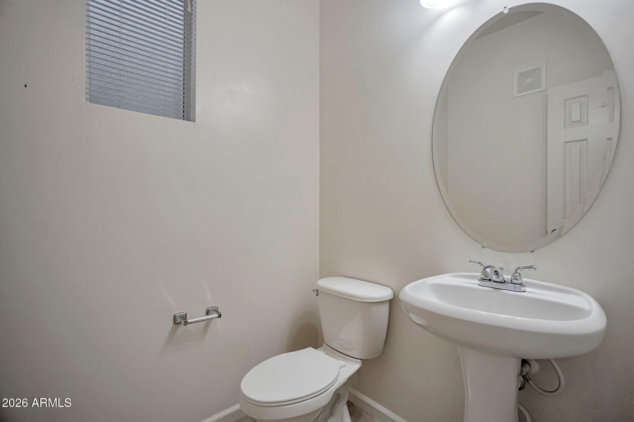 1920 East Bell Road, Unit 1006 Phoenix, AZ 85022 - Photo 14 of 25 a white toilet sitting next to a bathroom sink