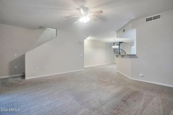 a view of a room with a ceiling fan and window