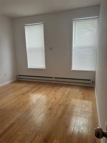 a view of a room with wooden floor and window
