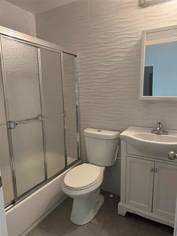 a white toilet sitting next to a bathroom sink