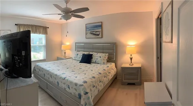 a bedroom with a bed and a refrigerator