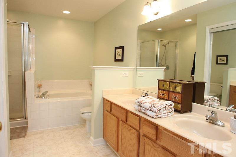 5430 Goldenglow Way Raleigh, NC 27606 - Photo 11 of 13 a bathroom with a granite countertop sink a toilet and shower