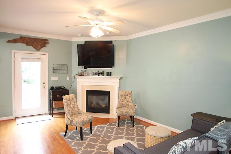5430 Goldenglow Way Raleigh, NC 27606 - Photo 3 of 13 a living room with furniture a fireplace and a flat screen tv