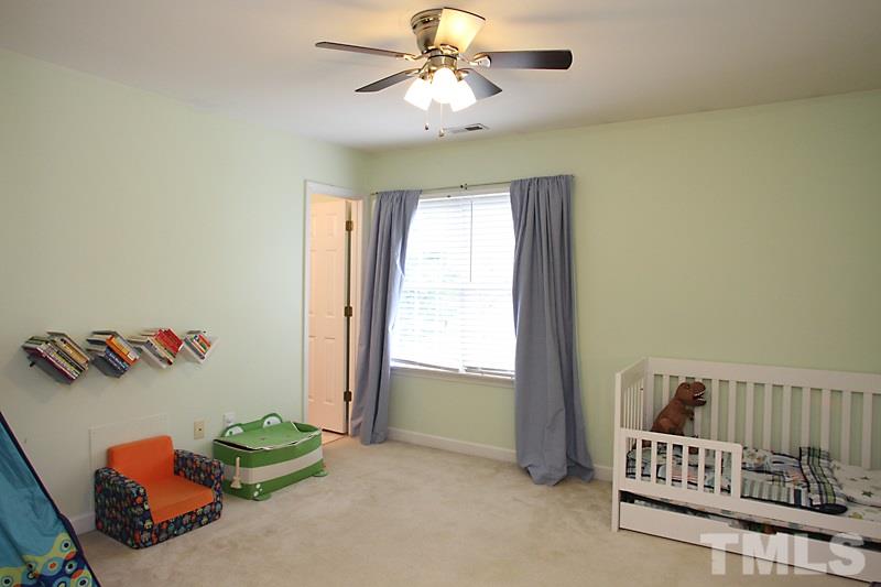 5430 Goldenglow Way Raleigh, NC 27606 - Photo 7 of 13 a bedroom with a bed and a chandelier