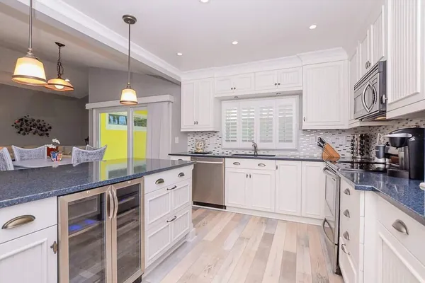 a kitchen with granite countertop a sink window and cabinets