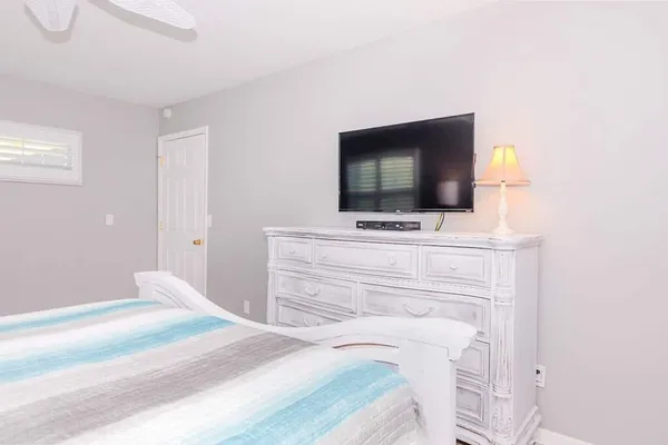 a bedroom with a bed and a flat screen tv