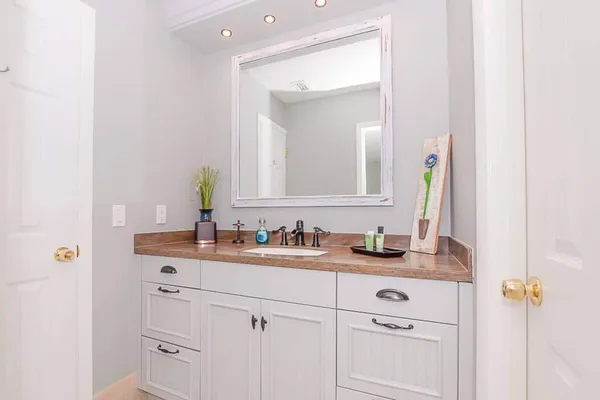 a bathroom with a sink a toilet a mirror and shower