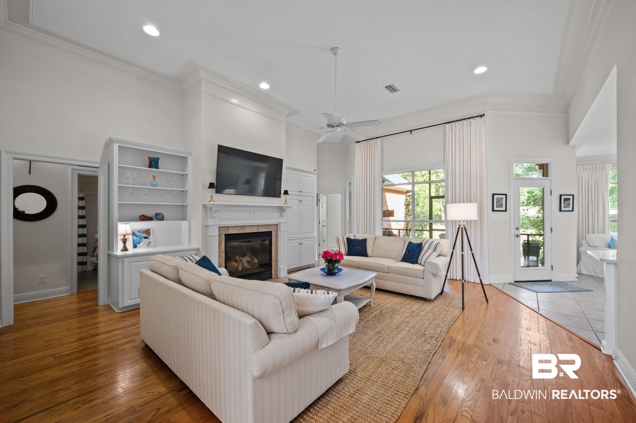 30151 Dolive Ridge Daphne, AL 36527 - Photo 5 of 37 Living area featuring a tiled fireplace, light wood-style floors, crown molding, and plenty of natural light