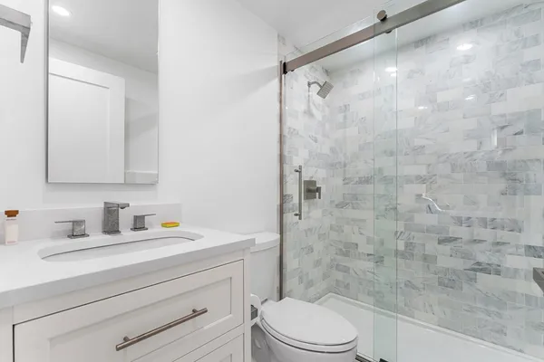 a bathroom with a sink a toilet and shower