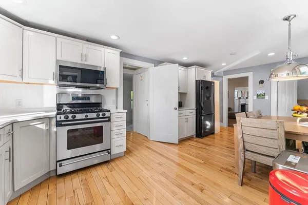 a kitchen with stainless steel appliances a stove a microwave and white cabinets