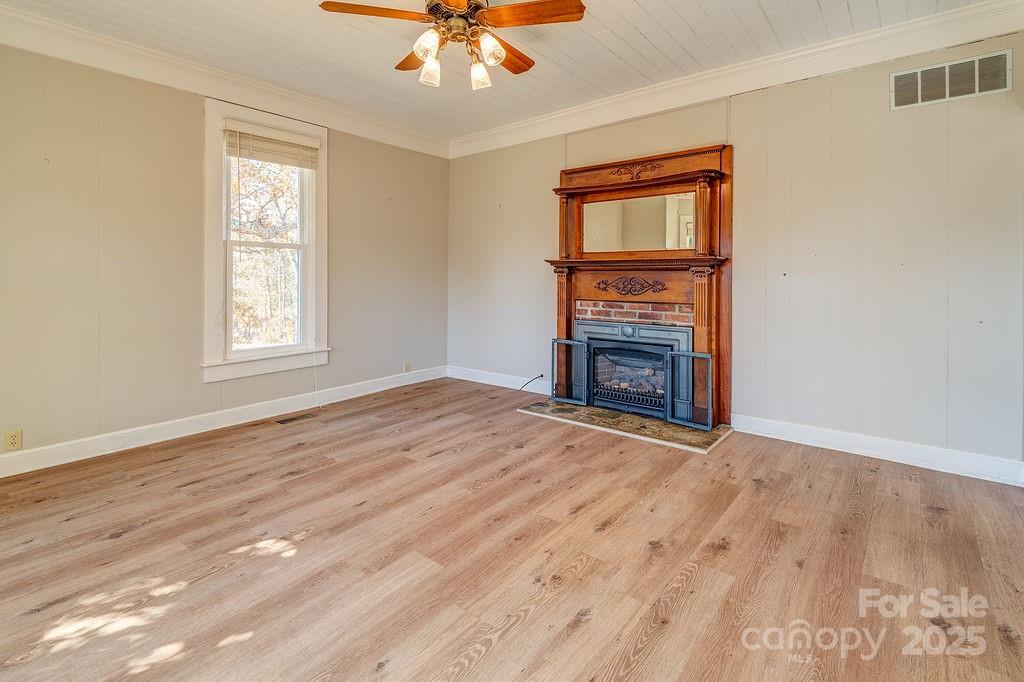 839 Jupiter Road Weaverville, NC 28787 - Photo 7 of 43 a view of an empty room with wooden floor fireplace and a window