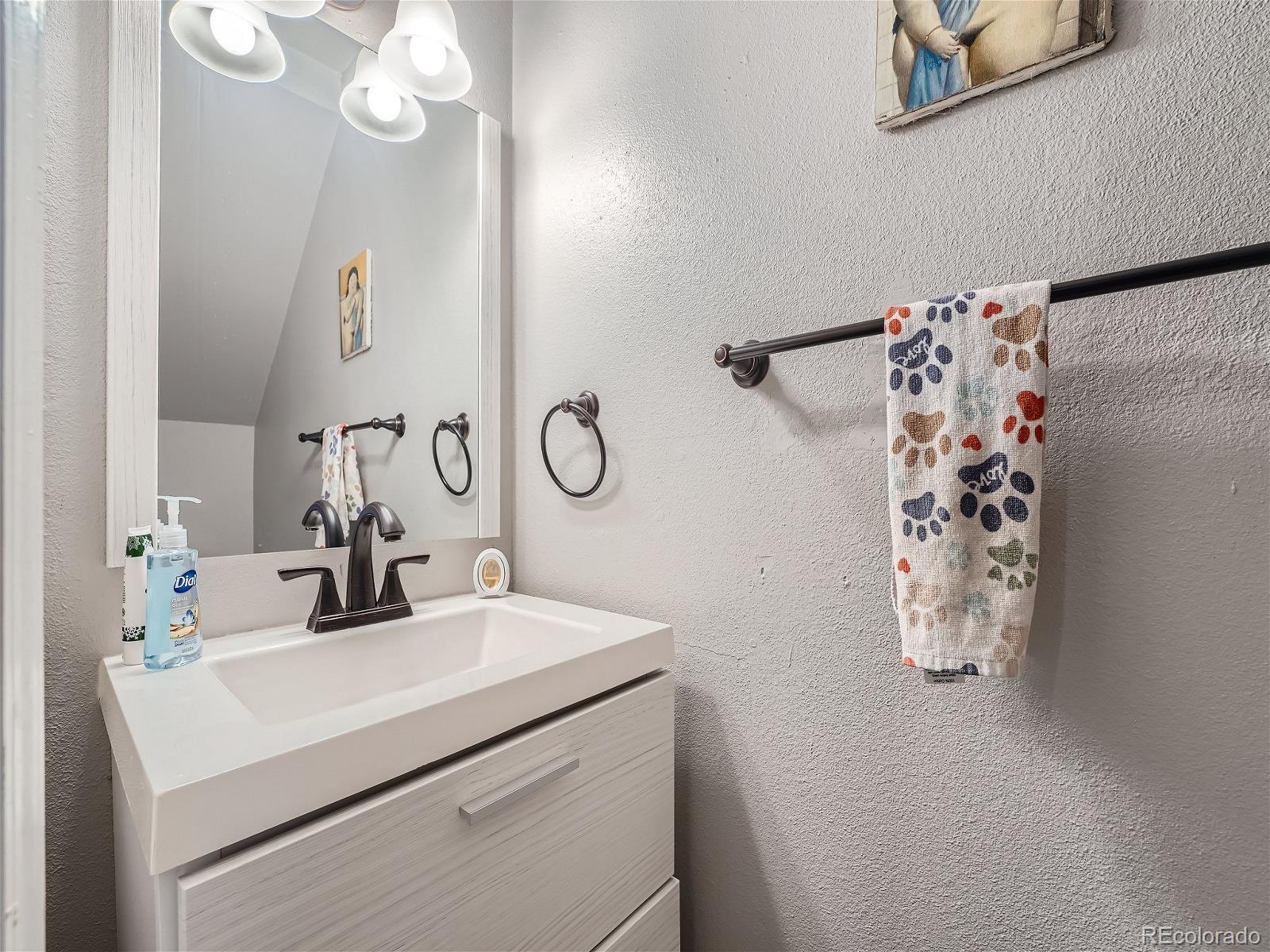 4911 Garrison Street, Unit 202G Wheat Ridge, CO 80033 - Photo 12 of 33 a bathroom with a sink and mirror