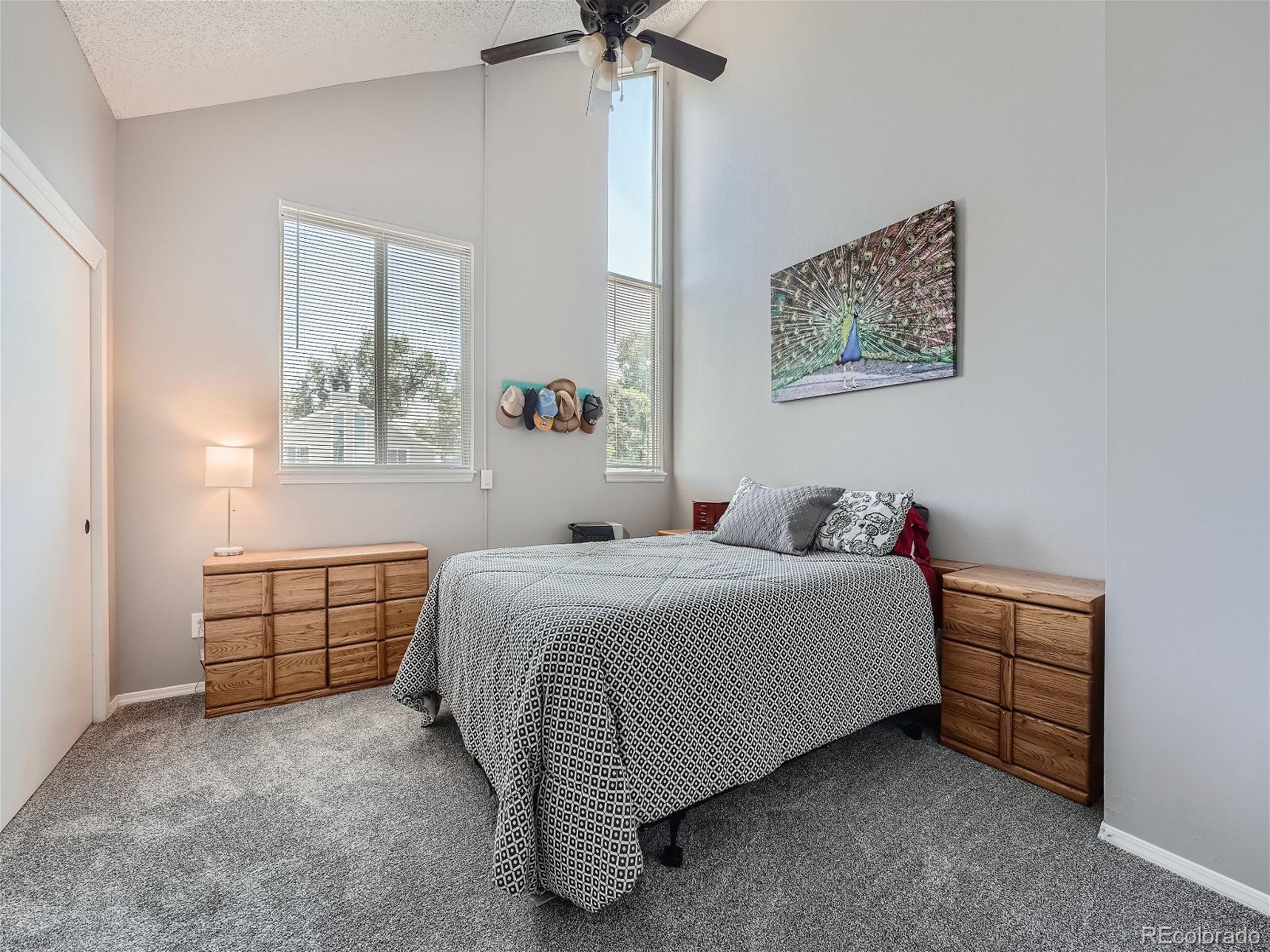 4911 Garrison Street, Unit 202G Wheat Ridge, CO 80033 - Photo 13 of 33 a bedroom with a bed and a chandelier
