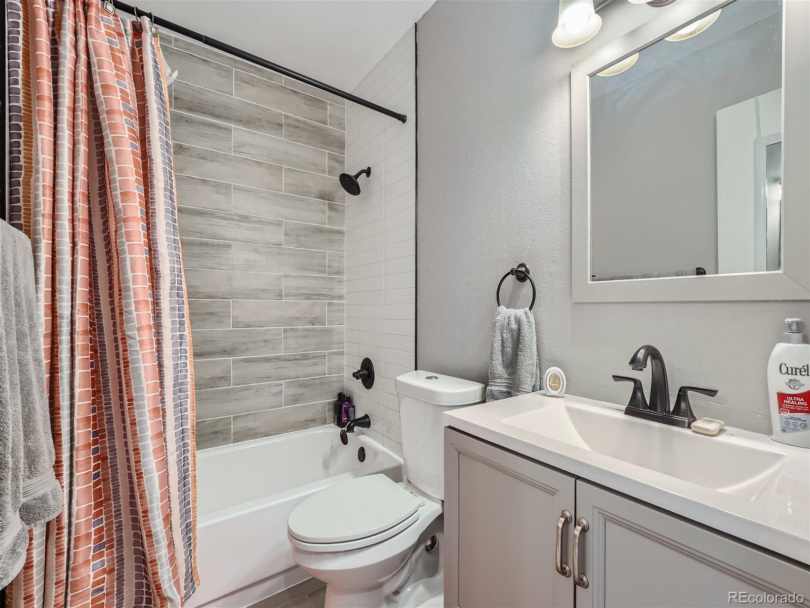 4911 Garrison Street, Unit 202G Wheat Ridge, CO 80033 - Photo 21 of 33 a bathroom with a sink toilet and shower