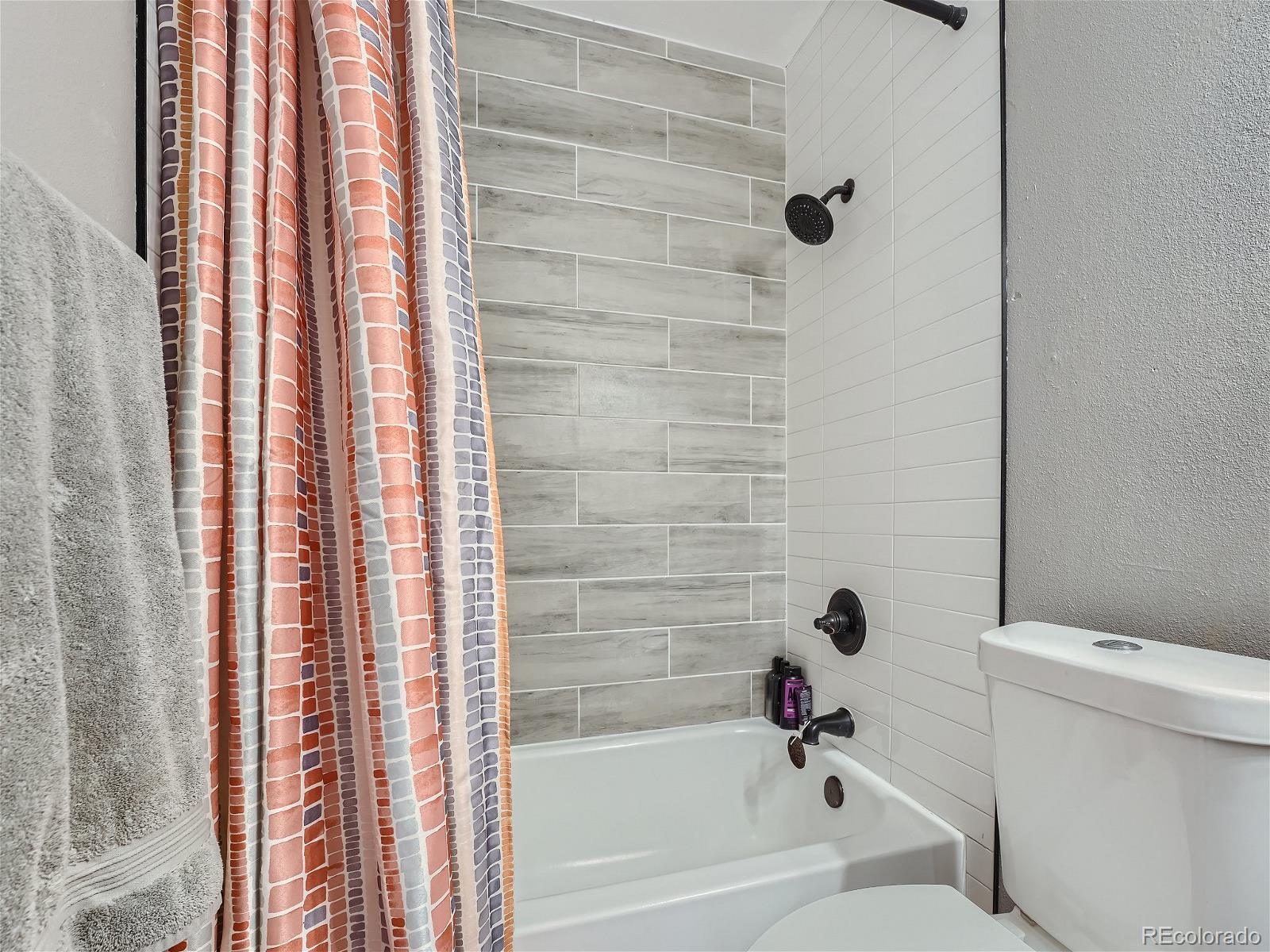 4911 Garrison Street, Unit 202G Wheat Ridge, CO 80033 - Photo 22 of 33 a bathroom with a bathtub and a shower