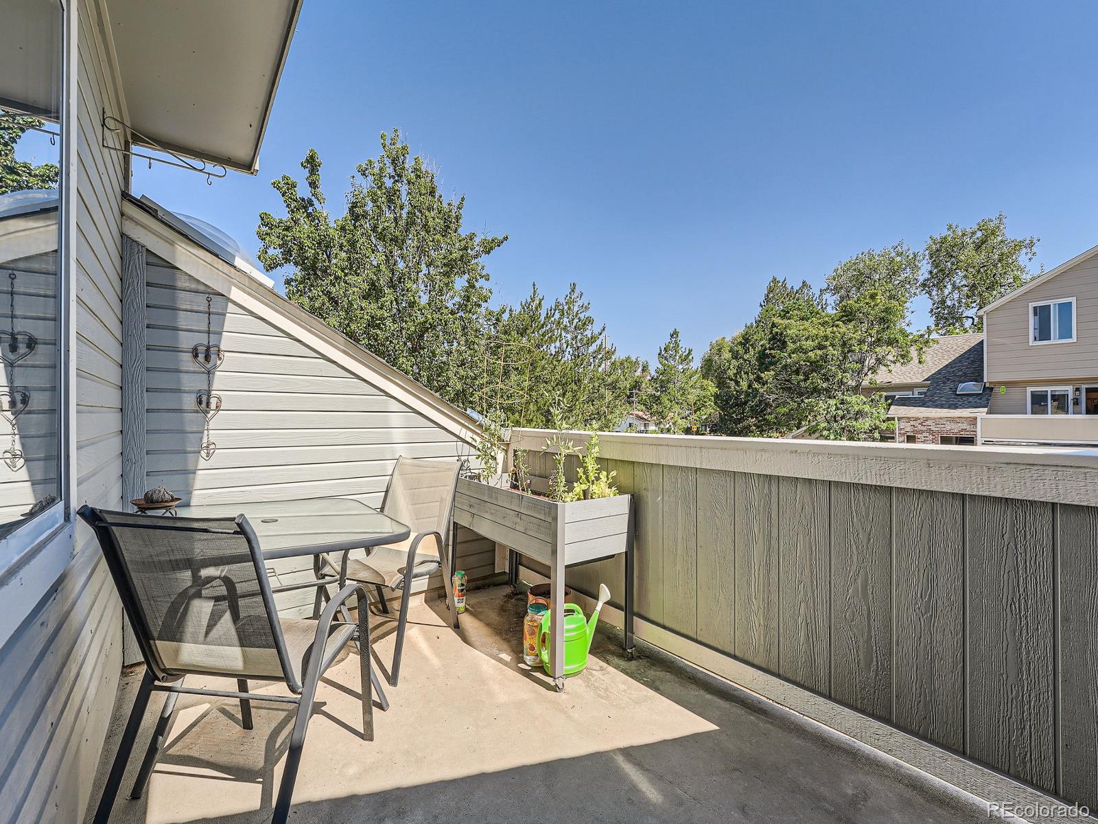 4911 Garrison Street, Unit 202G Wheat Ridge, CO 80033 - Photo 25 of 33 a view of a patio with table and chairs with wooden fence and plants