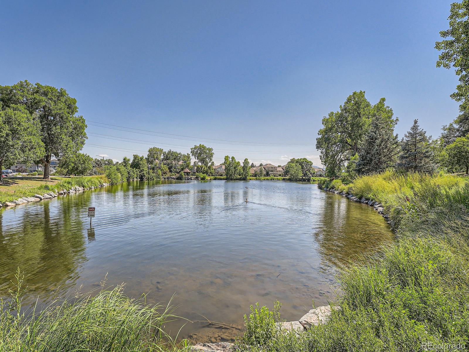 4911 Garrison Street, Unit 202G Wheat Ridge, CO 80033 - Photo 30 of 33 a view of a lake with houses in the back