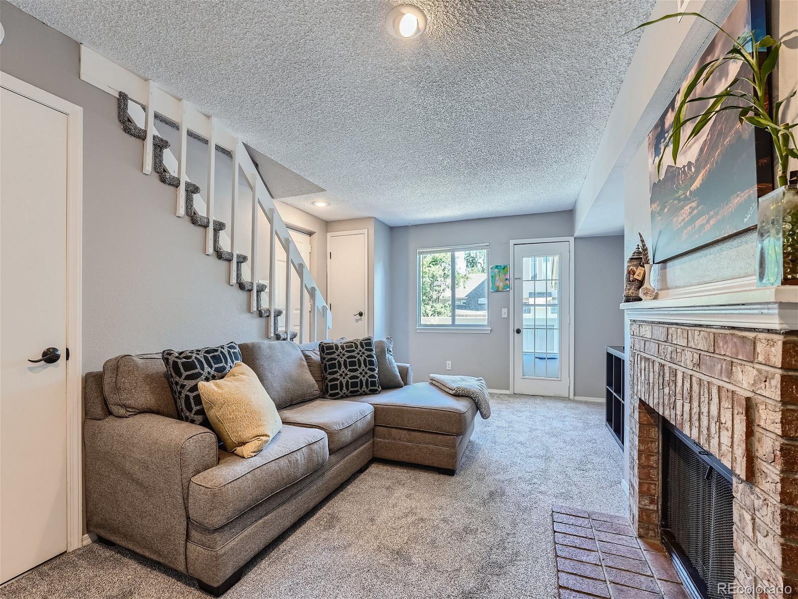4911 Garrison Street, Unit 202G Wheat Ridge, CO 80033 - Photo 3 of 33 a living room with furniture and a fireplace