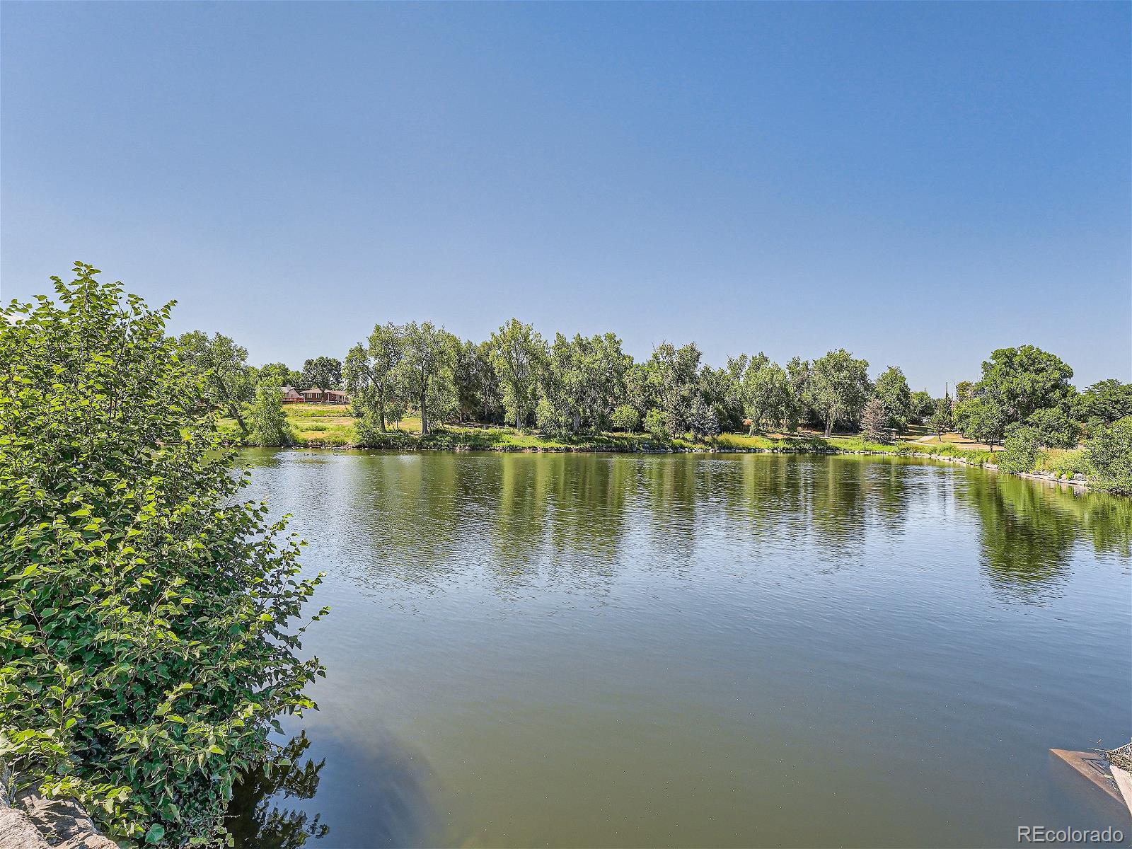 4911 Garrison Street, Unit 202G Wheat Ridge, CO 80033 - Photo 31 of 33 a view of a lake with houses in the background