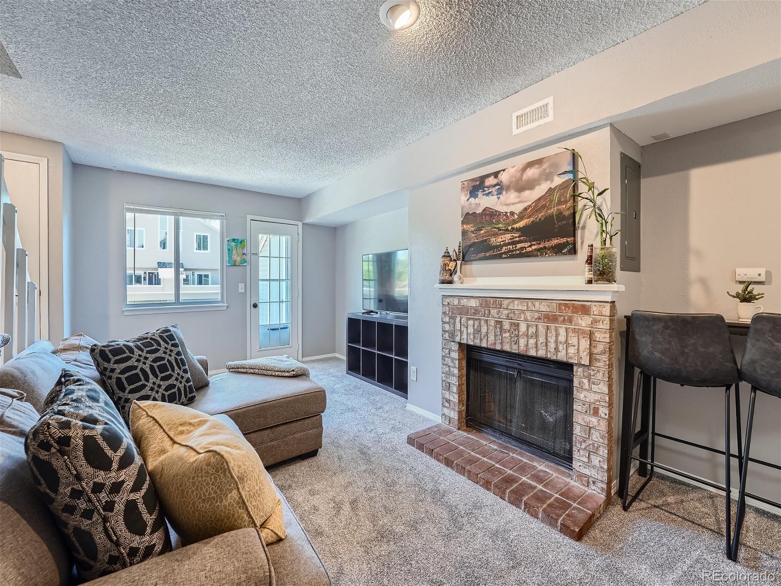 4911 Garrison Street, Unit 202G Wheat Ridge, CO 80033 - Photo 4 of 33 a bedroom with a bed and a fireplace