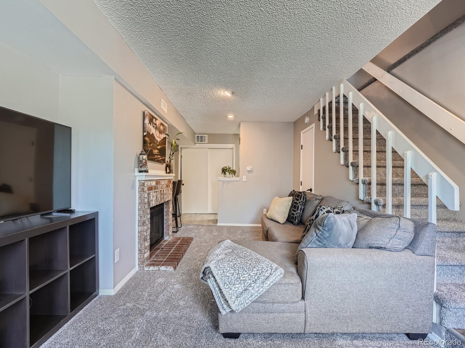4911 Garrison Street, Unit 202G Wheat Ridge, CO 80033 - Photo 6 of 33 a living room with furniture and a flat screen tv