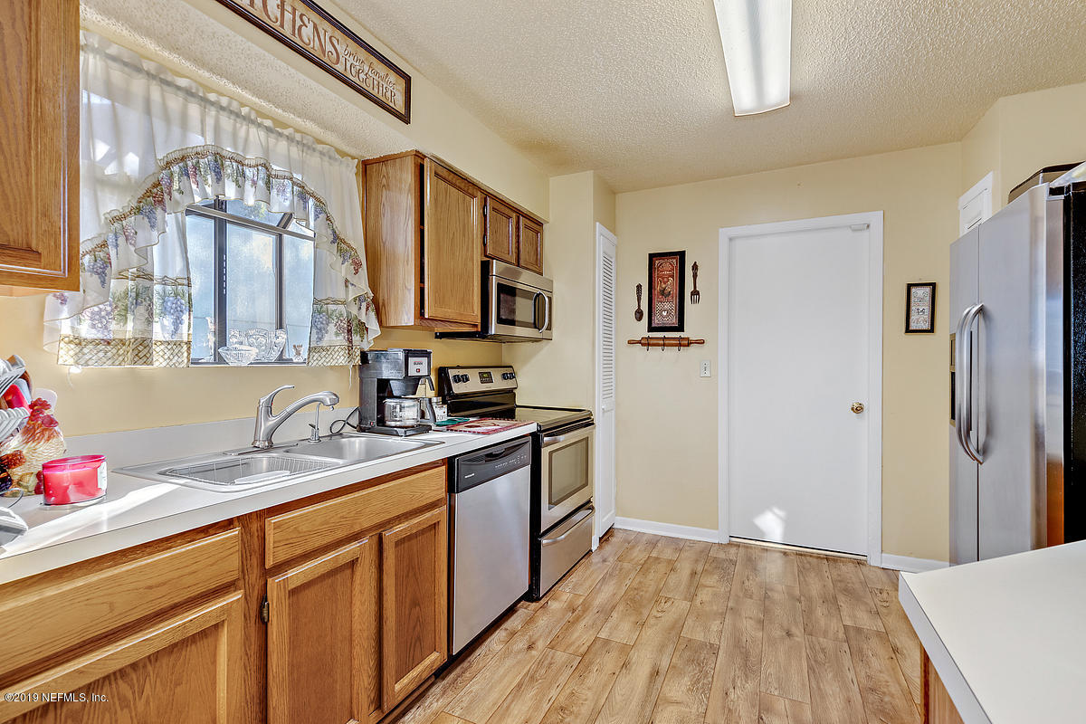 12819 Beaubien Road Jacksonville, FL 32258 - Photo 12 of 17 a kitchen with a sink cabinets stainless steel appliances and a window