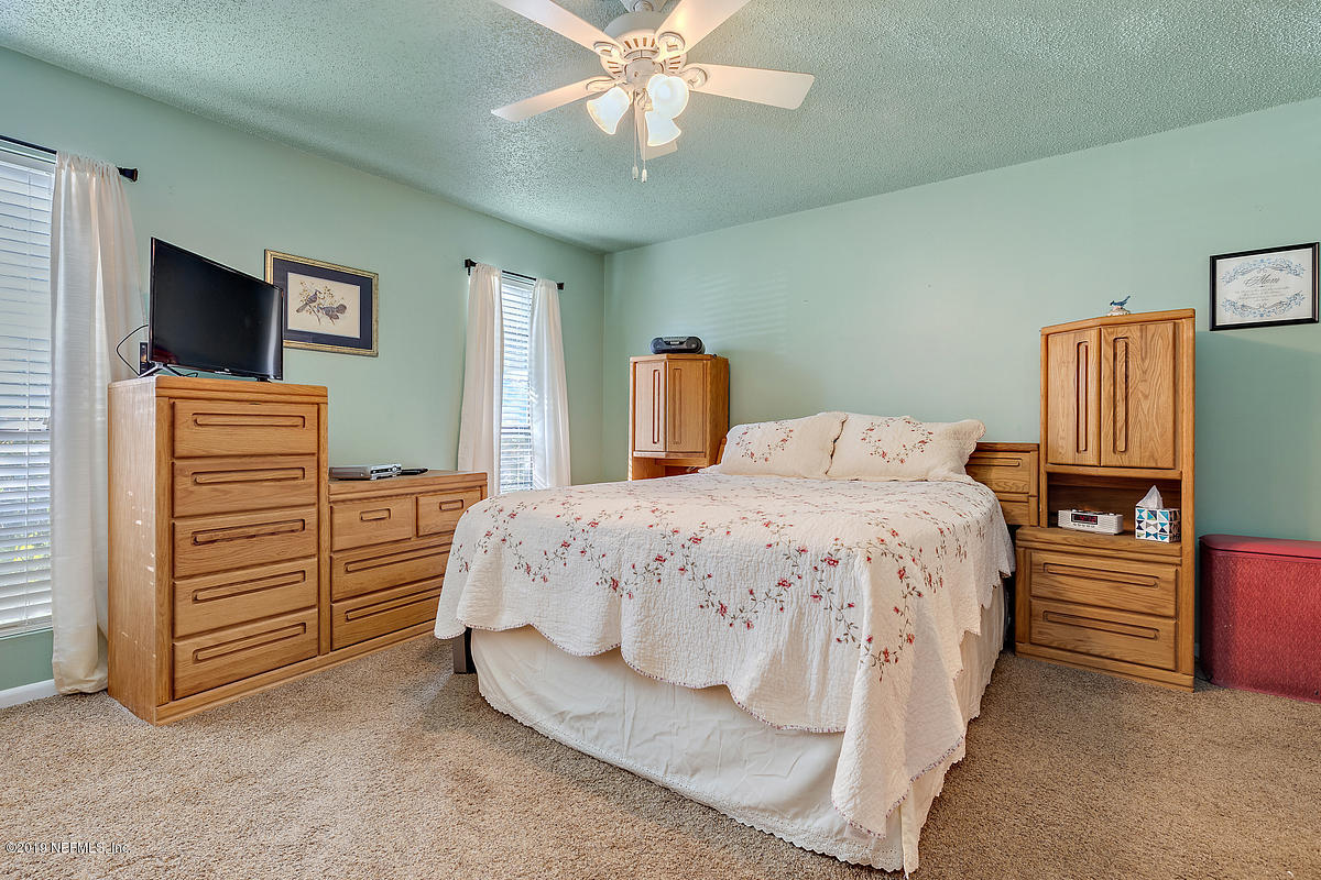 12819 Beaubien Road Jacksonville, FL 32258 - Photo 7 of 17 a bedroom with a bed and a flat tv screen on dresser